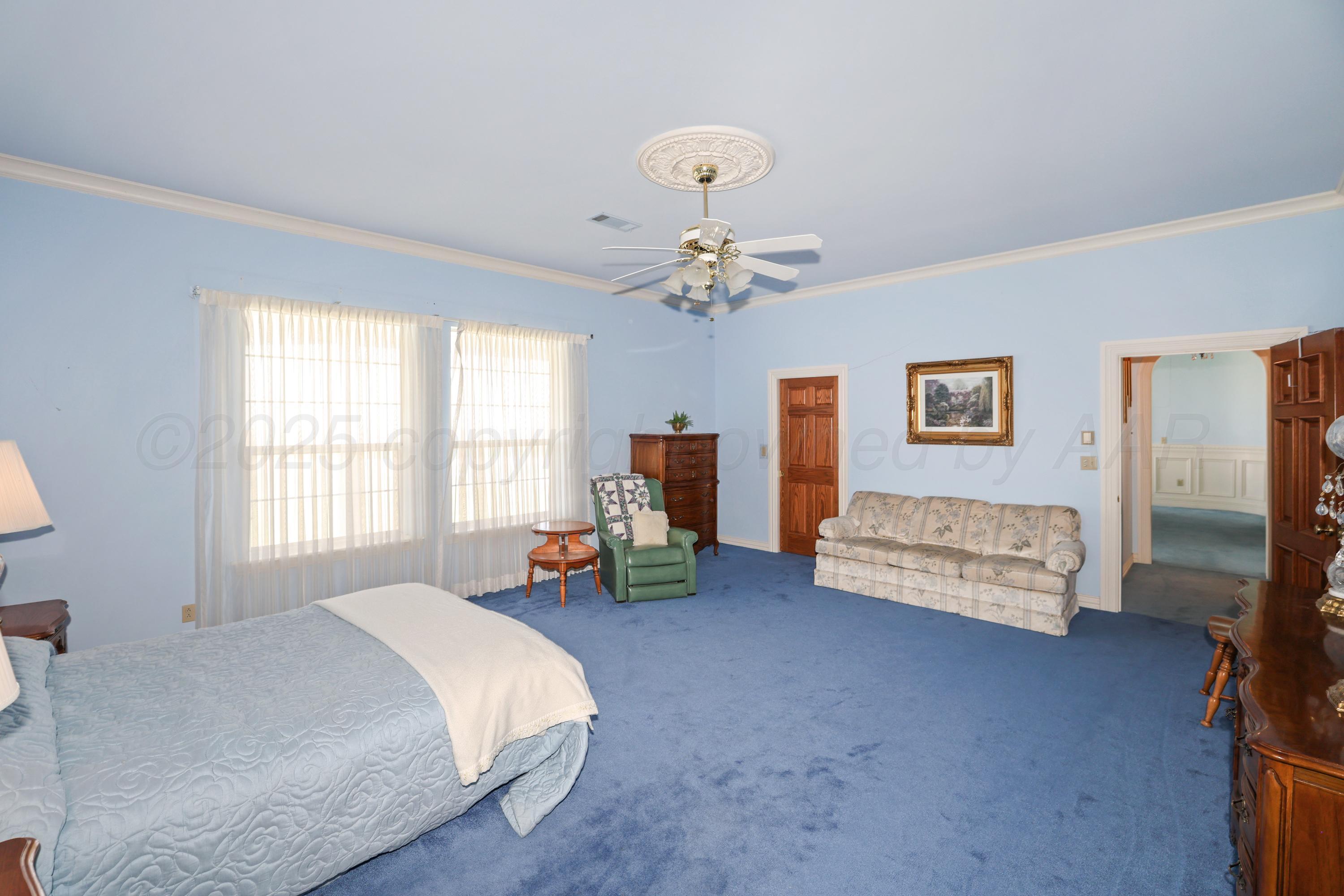 1401 County Road K Panhandle, TX 79068 - Photo 16 of 53 a bed room with a bed and a chair