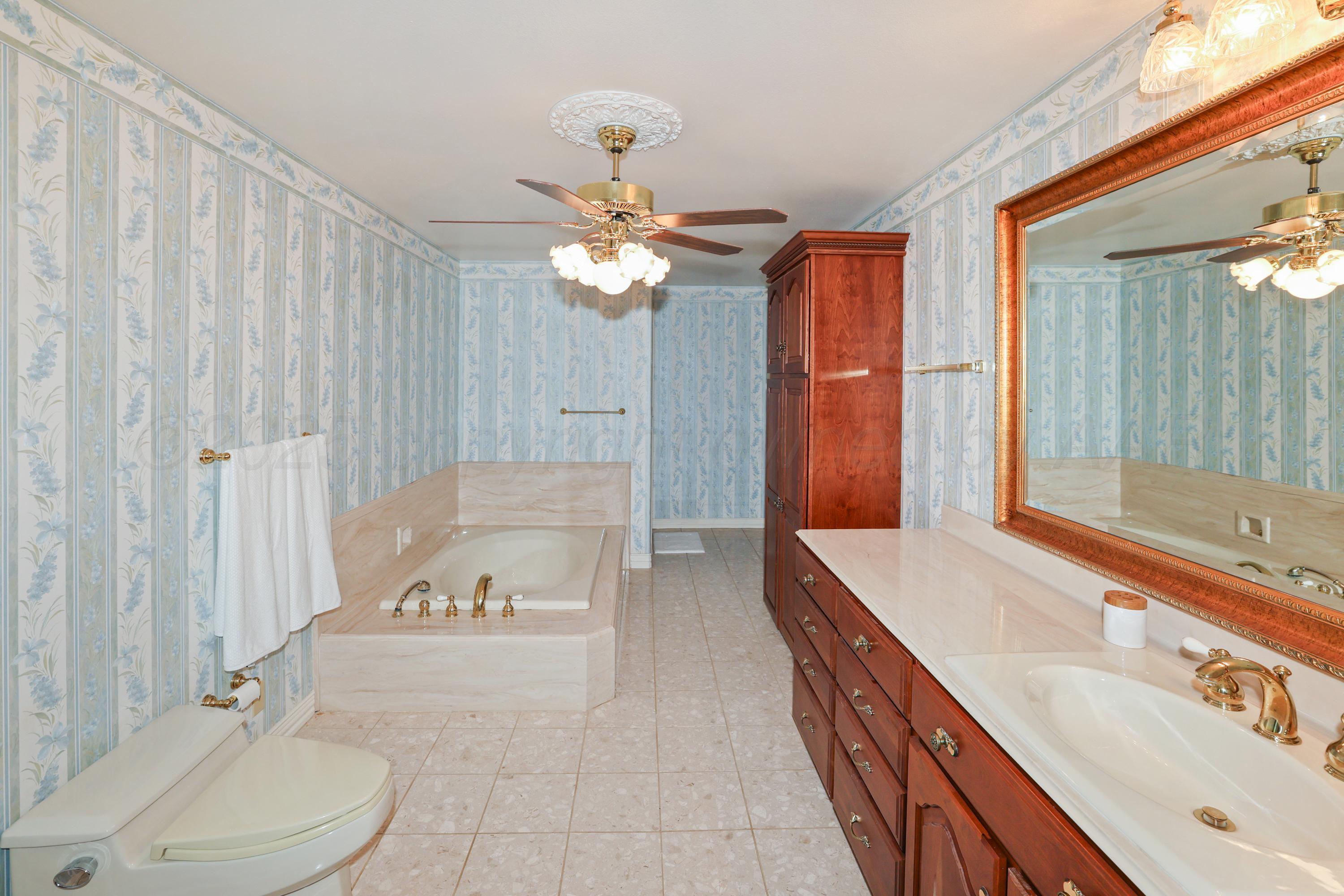 1401 County Road K Panhandle, TX 79068 - Photo 18 of 53 a bathroom with a tub sink and mirror