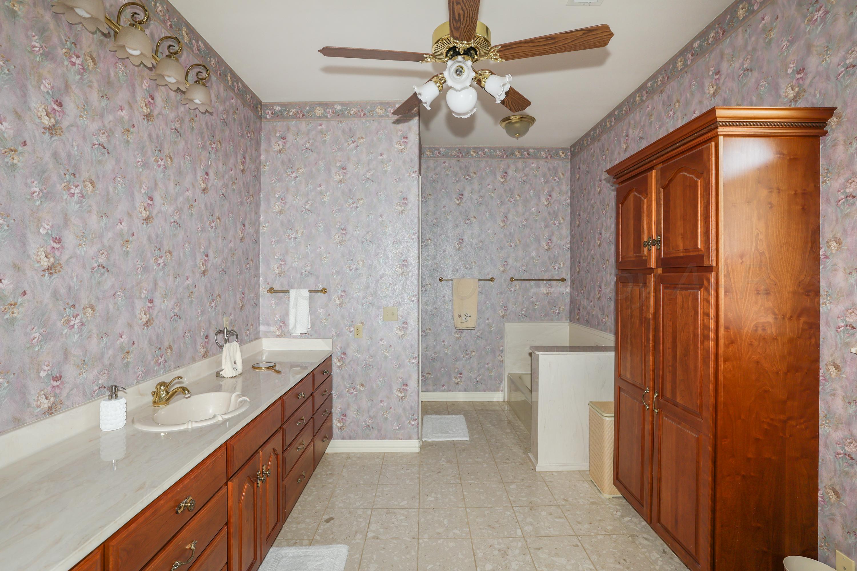 1401 County Road K Panhandle, TX 79068 - Photo 33 of 53 a bathroom with a tub a sink and a large mirror