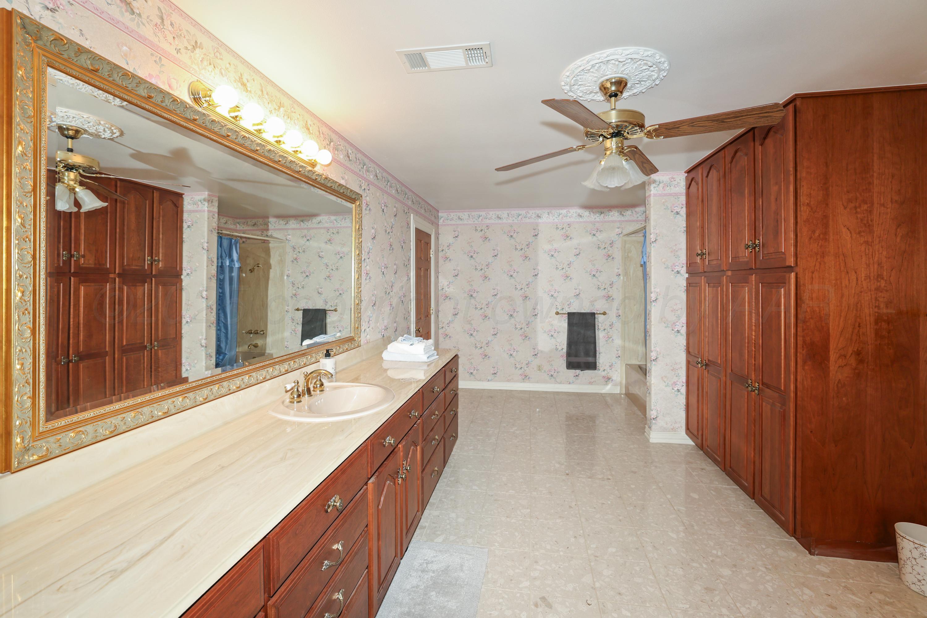 1401 County Road K Panhandle, TX 79068 - Photo 38 of 53 a spacious bathroom with a double vanity sink a large mirror and shower