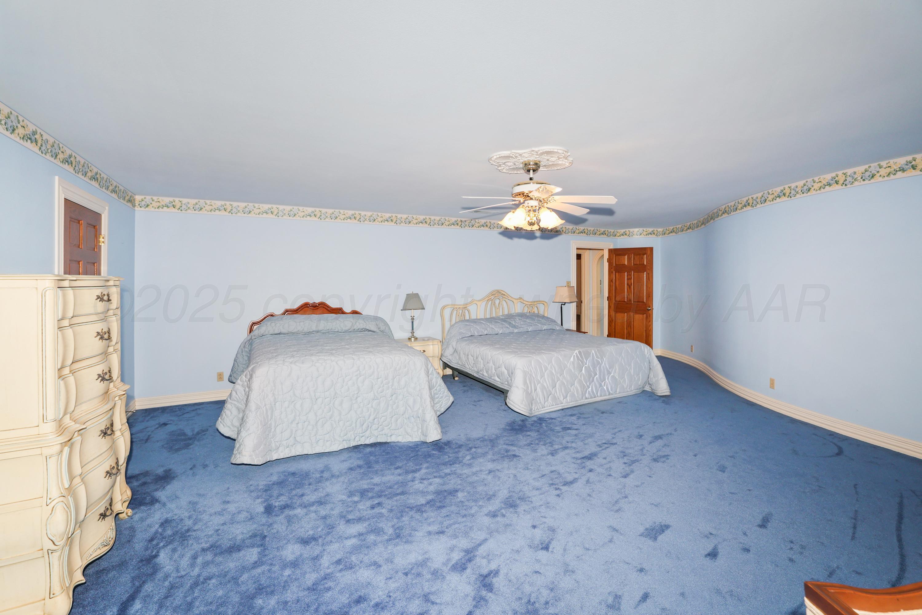 1401 County Road K Panhandle, TX 79068 - Photo 45 of 53 a spacious bedroom with two beds and a chandelier