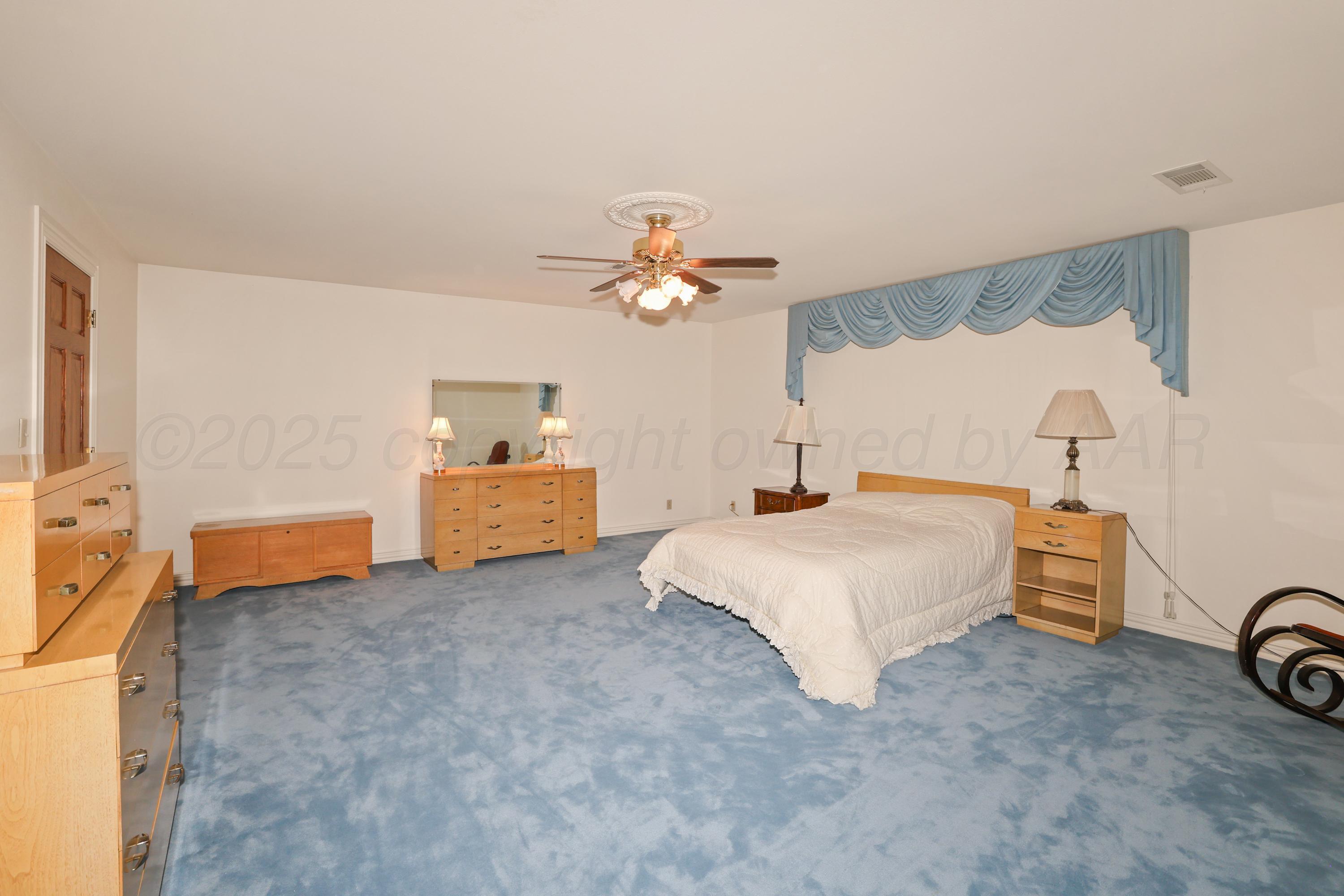 1401 County Road K Panhandle, TX 79068 - Photo 52 of 53 a spacious bedroom with a bed and a chandelier