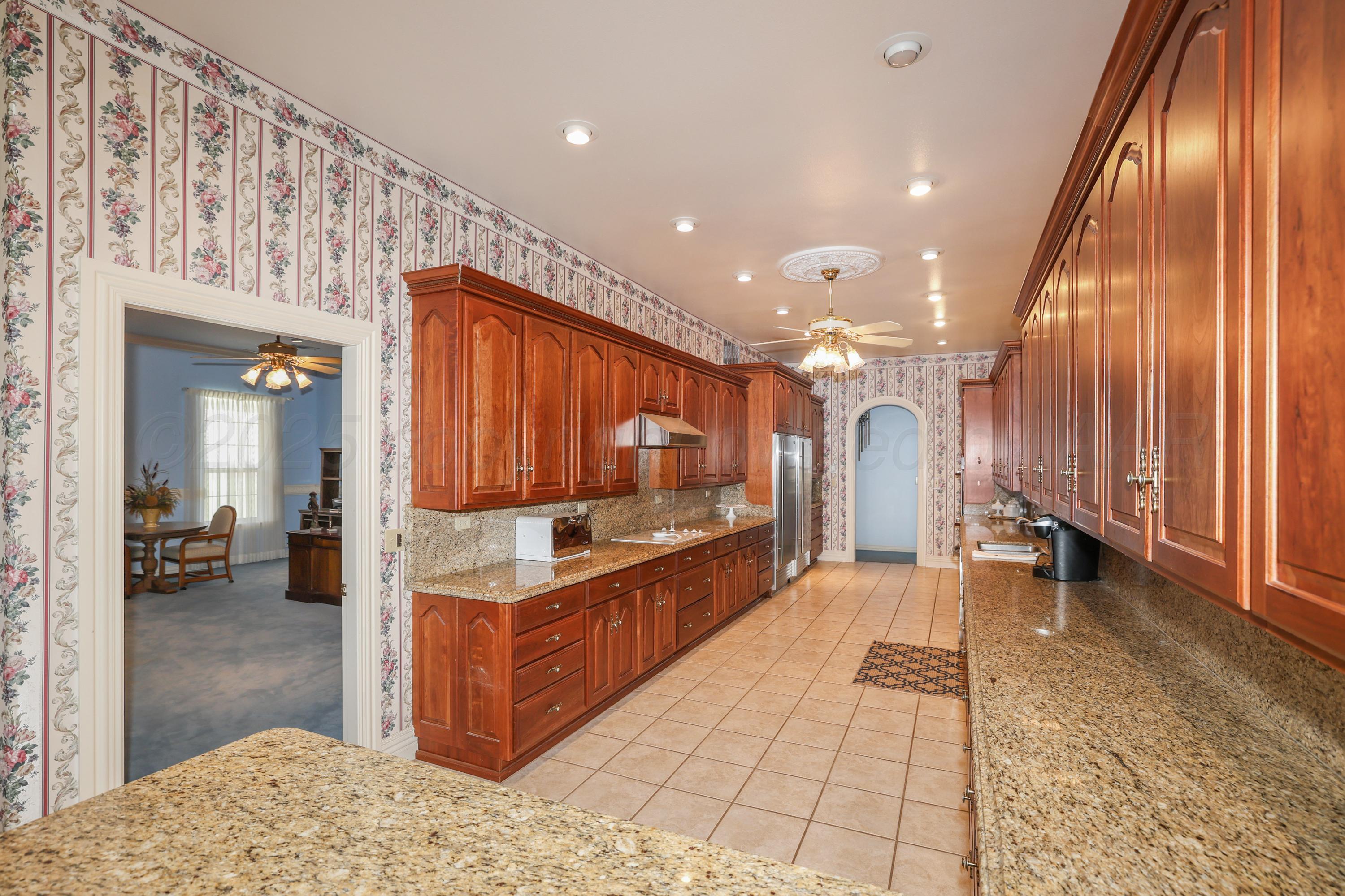 1401 County Road K Panhandle, TX 79068 - Photo 7 of 53 a kitchen with stainless steel appliances kitchen island granite countertop a refrigerator and a sink
