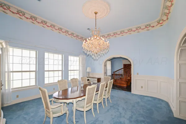 a dining room with furniture a chandelier and window