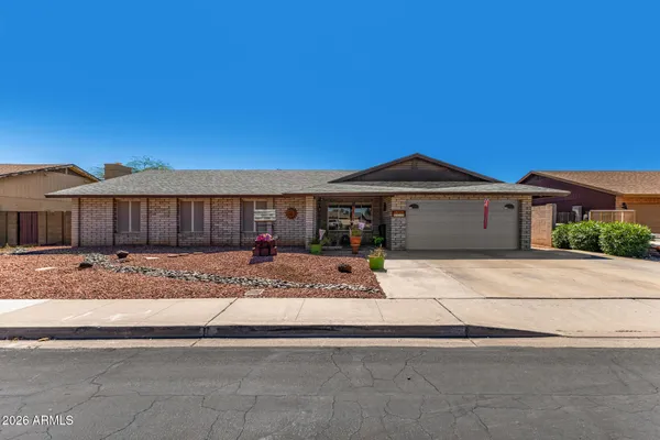 a front view of a house with a garden and garage