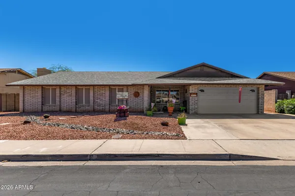 a front view of a house with a garden and yard