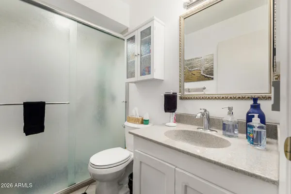 a bathroom with a granite countertop sink a large mirror and toilet