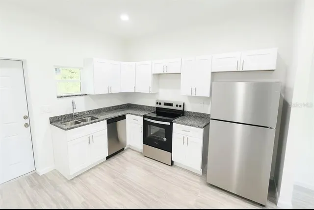 a kitchen with a refrigerator sink and stove top oven