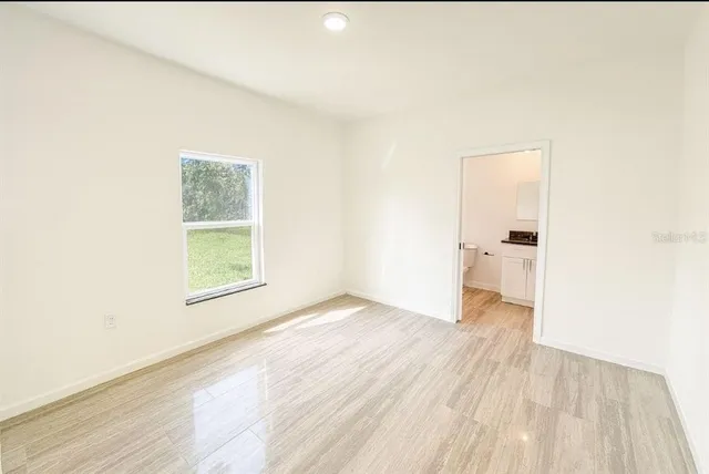 an empty room with wooden floor and a window