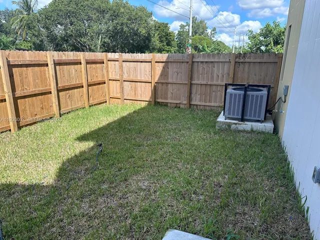 a view of a backyard with a wooden fence