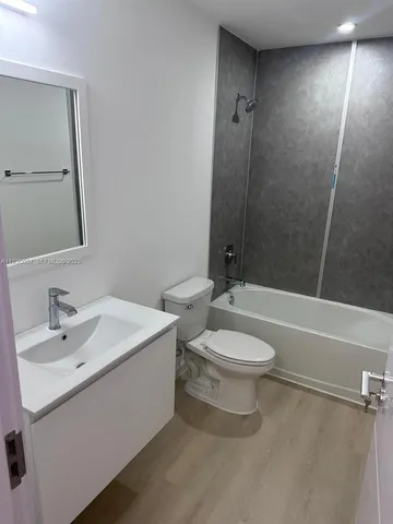 a bathroom with a toilet a sink a mirror and shower