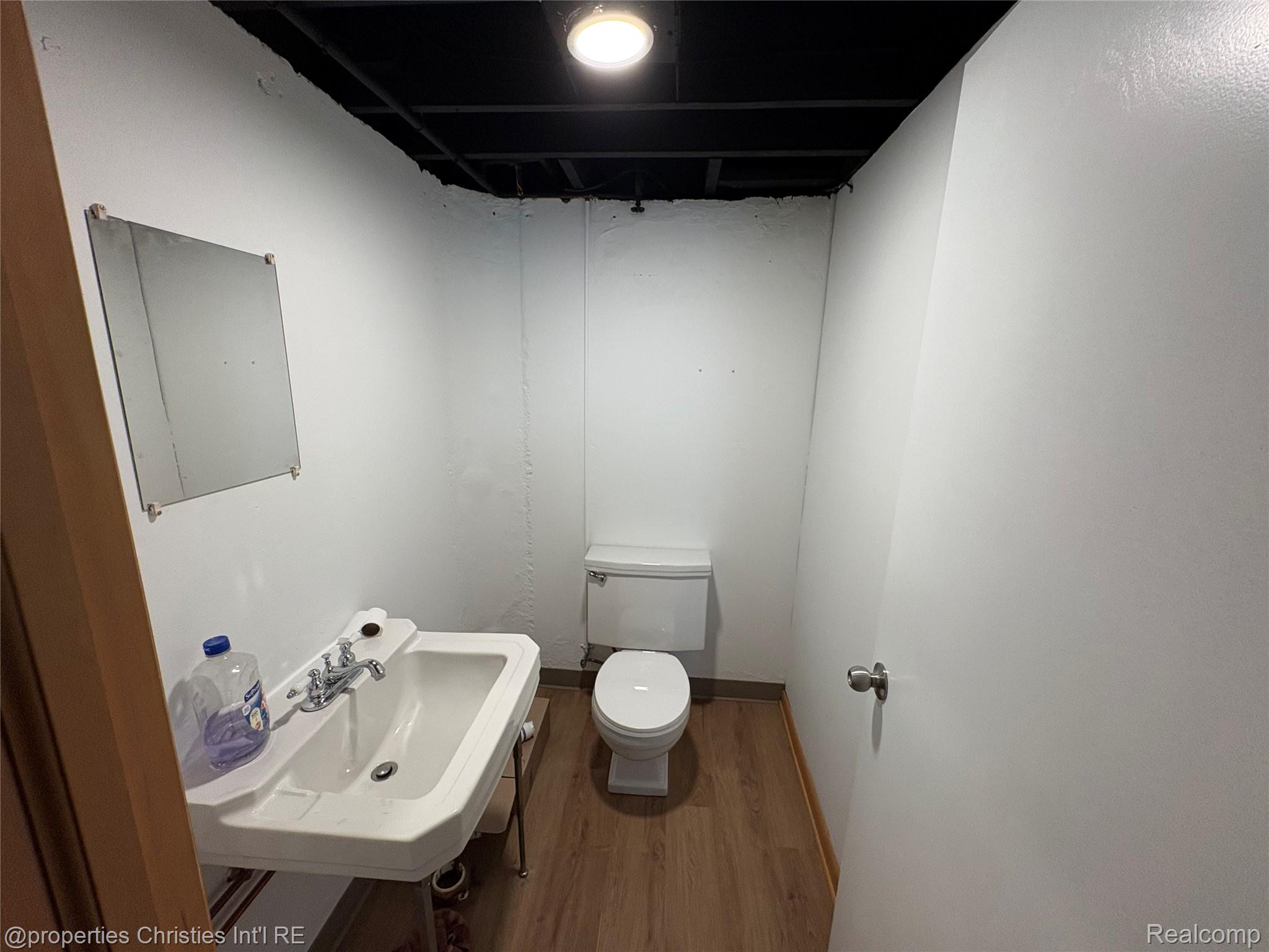 17330 Beverly Road Franklin, MI 48025 - Photo 21 of 24 Half bath featuring toilet and dark wood-style floors