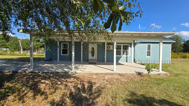 a view of a house with a tree in front of it