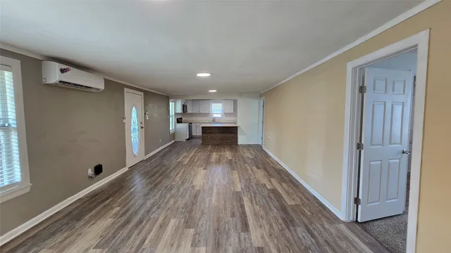 a view of a room with wooden floor electronic appliances and window
