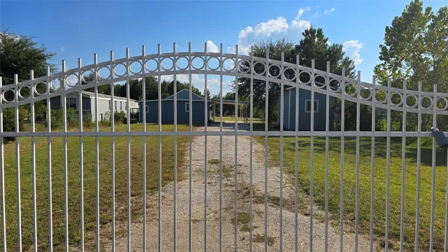 a view of a house with swimming pool and wooden fence