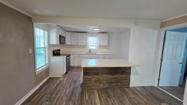 a kitchen with wooden floors and kitchen view