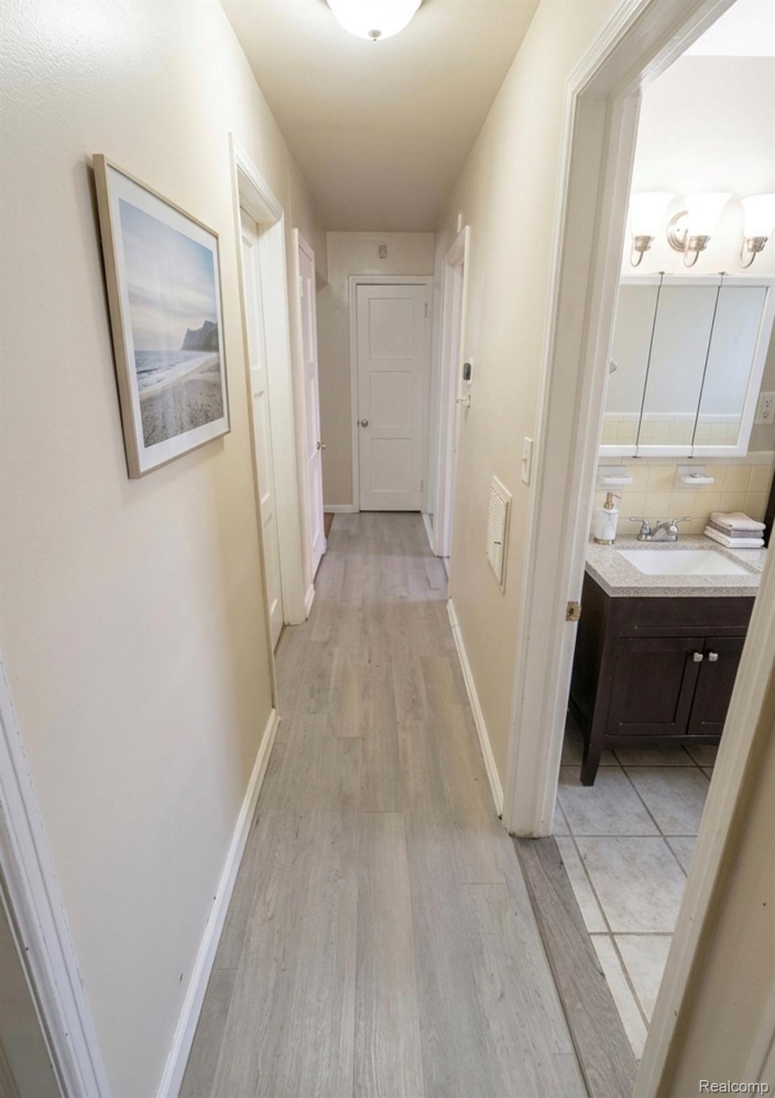 Corridor with baseboards and light wood-style floors