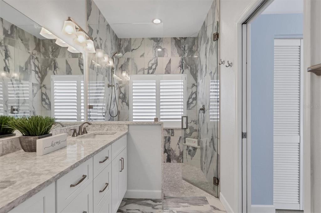 5956 Rachele Drive Sarasota, FL 34243 - Photo 19 of 37 a bathroom with a granite countertop sink a mirror and shower