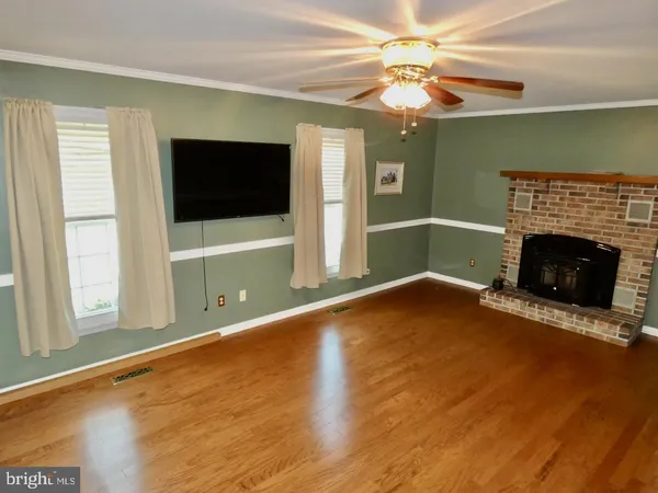 a kitchen with stainless steel appliances wooden cabinets and a wooden floor