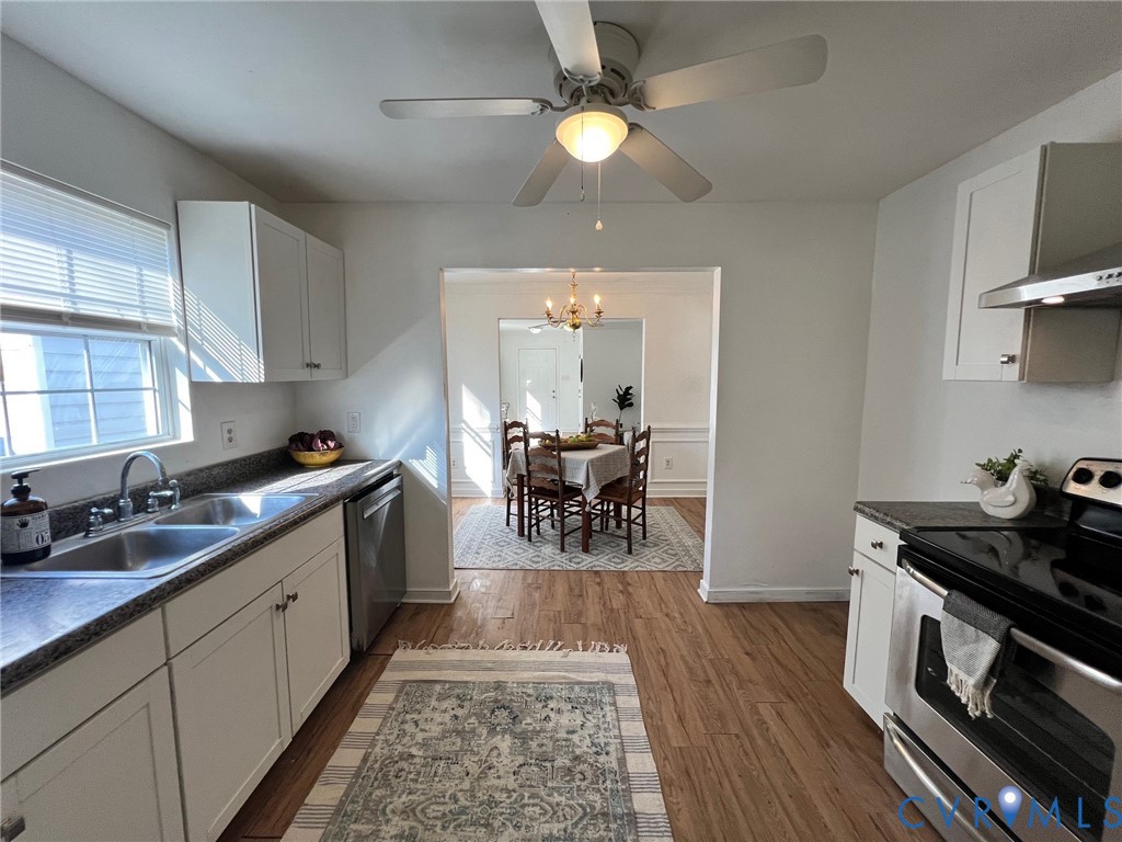 2604 Perry Street Richmond, VA 23225 - Photo 14 of 30 a kitchen with a dining table chairs and white cabinets