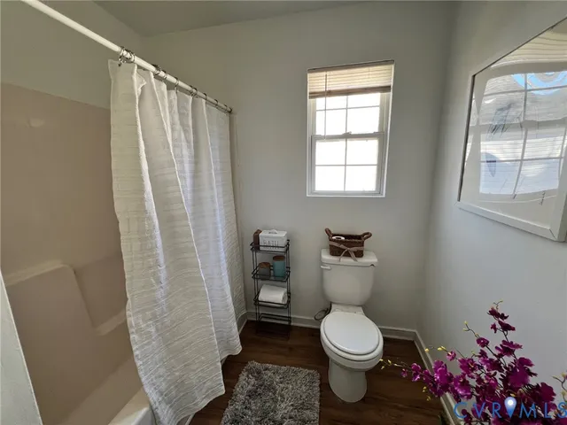 a white toilet sitting next to a bathroom sink and a window