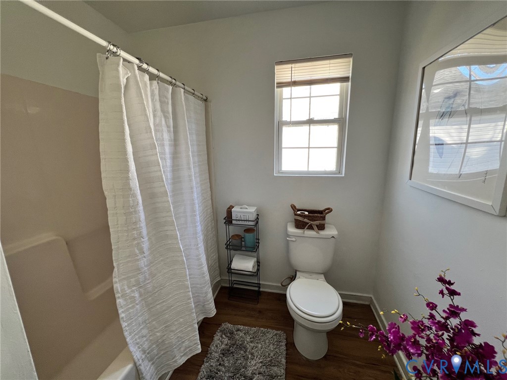 2604 Perry Street Richmond, VA 23225 - Photo 21 of 30 a white toilet sitting next to a bathroom sink and a window