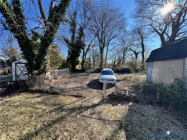 a view of a backyard with table and chairs under a large tree