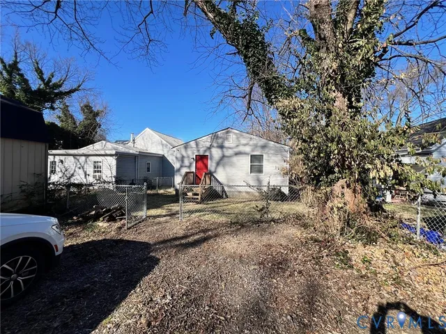 a view of multiple house with large trees and potted plants