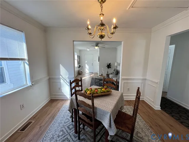 a view of a dining room with furniture a chandelier and wooden floor