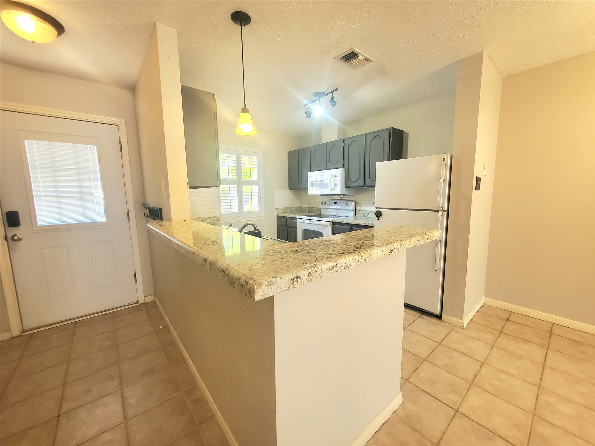 2030 Plantation Drive, Unit B2 Conroe, TX 77301 - Photo 6 of 20 a kitchen with a sink a refrigerator a counter top space and cabinets