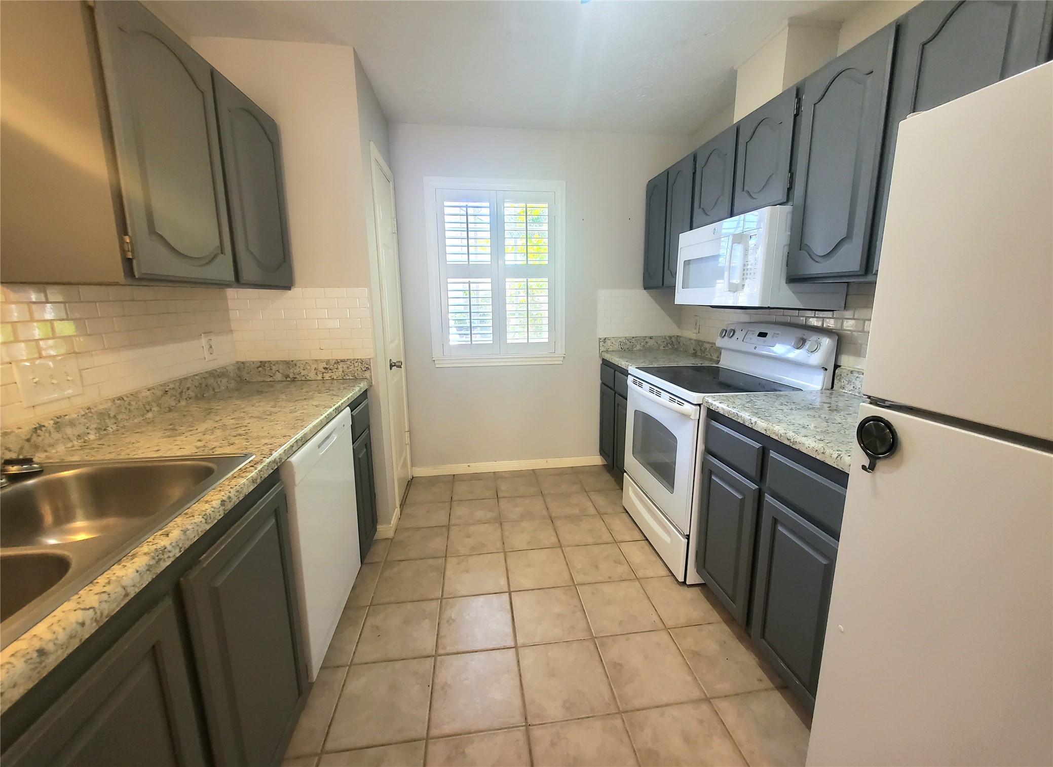 2030 Plantation Drive, Unit B2 Conroe, TX 77301 - Photo 8 of 20 a kitchen with a sink a stove top oven and a refrigerator