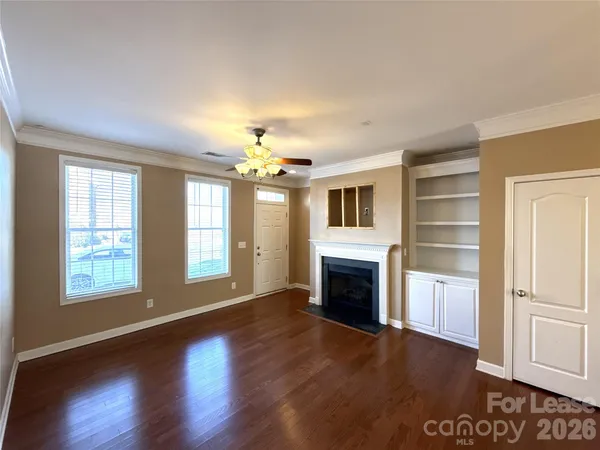 a view of an empty room with a fireplace and a window