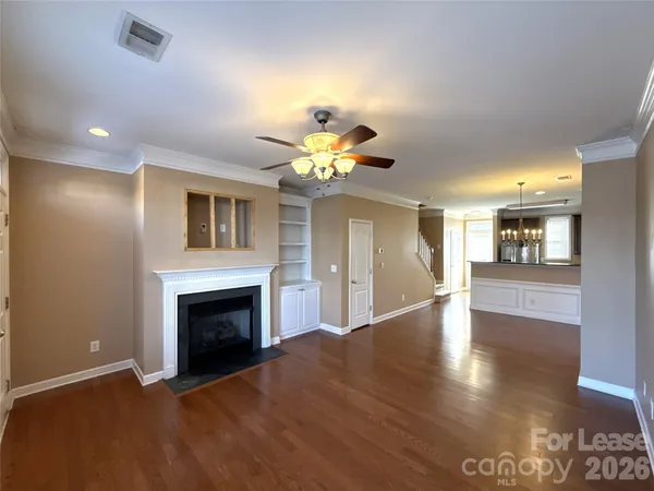 a view of a livingroom with a fireplace a chandelier and wooden floor