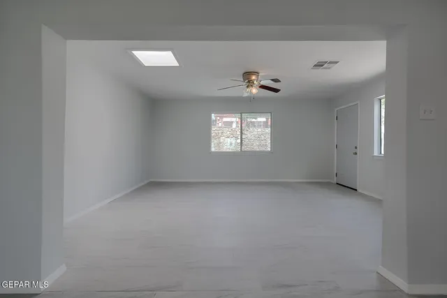 an empty room with windows and mirror