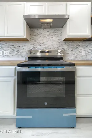 a kitchen with granite countertop white cabinets and white appliances