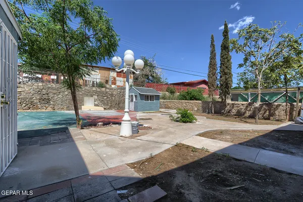 a backyard of a house with table and chairs and potted plants