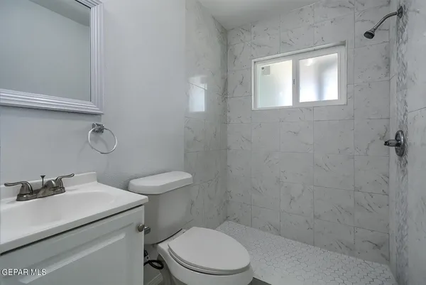 a bathroom with a toilet sink vanity and window