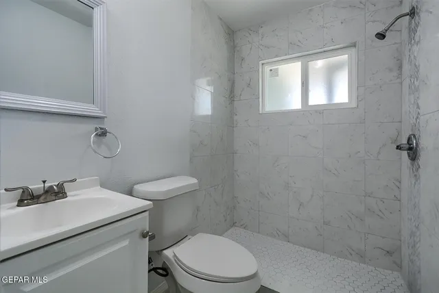 a bathroom with a toilet sink vanity and window