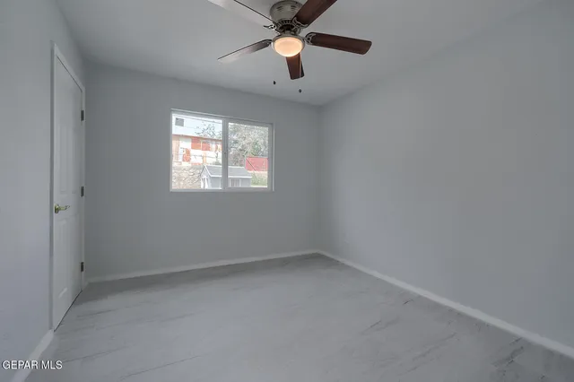 an empty room with closet and a window