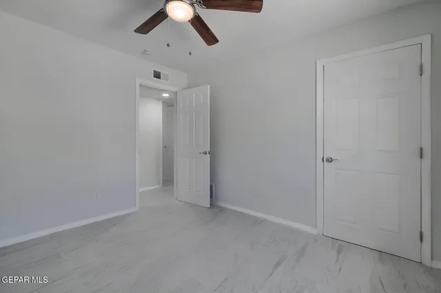 an empty room with chandelier fan