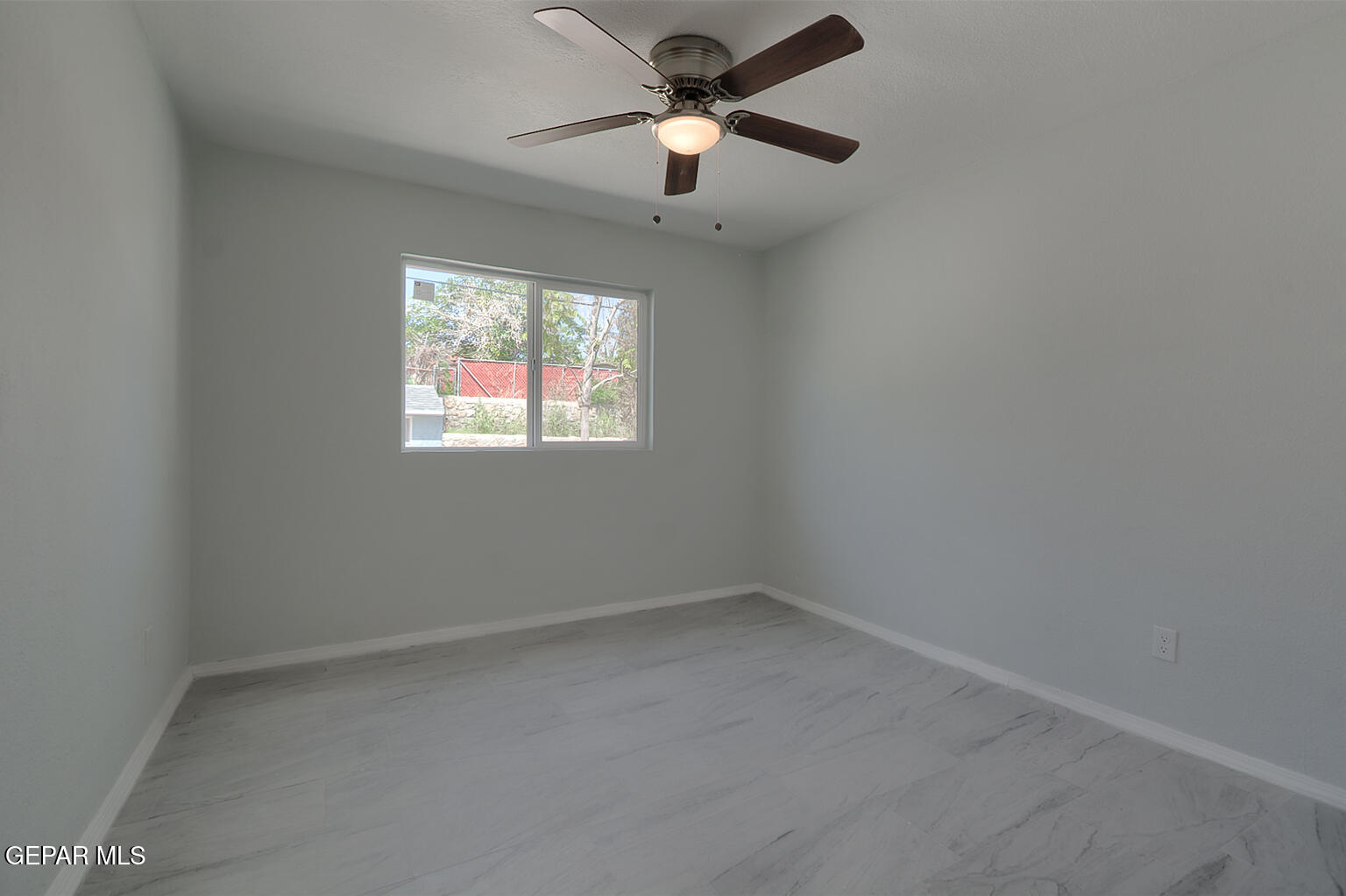 6247 Arapaho Road El Paso, TX 79905 - Photo 10 of 43 an empty room with a window and a fan