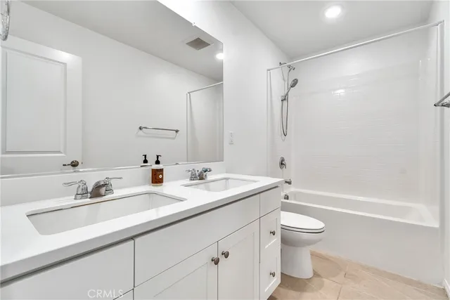 a bathroom with a sink double vanity granite toilet tub and shower