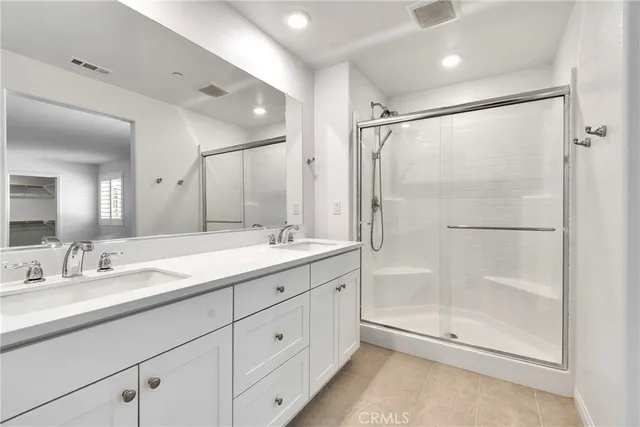 a bathroom with a shower sink vanity and mirror