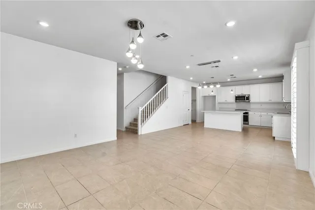 a view of a living room a ceiling fan and kitchen view