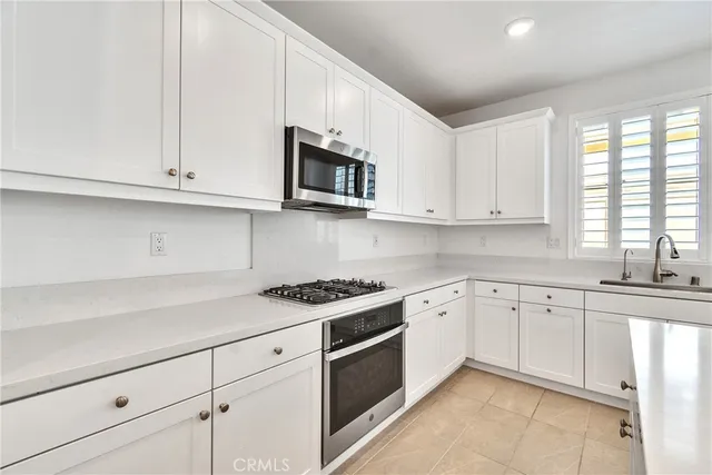 a kitchen with stainless steel appliances granite countertop white cabinets a sink and dishwasher