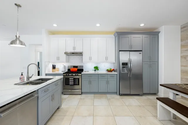 a kitchen with a sink a refrigerator and cabinets