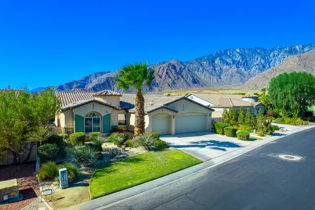 a front view of a house with a yard and potted plants