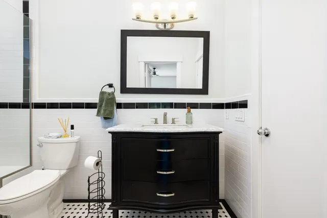 a bathroom with a toilet sink and mirror
