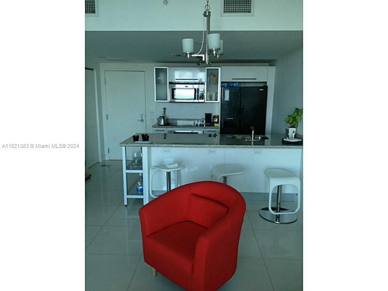 185 Southwest 7th Street, Unit 3408 Miami, FL 33130 - Photo 2 of 14 a view of a kitchen with a sink and a mirror
