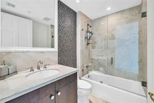 a kitchen with stainless steel appliances granite countertop a sink a stove and a wooden cabinets